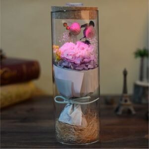 Pink flower bouquet displayed inside a tall glass- A70
